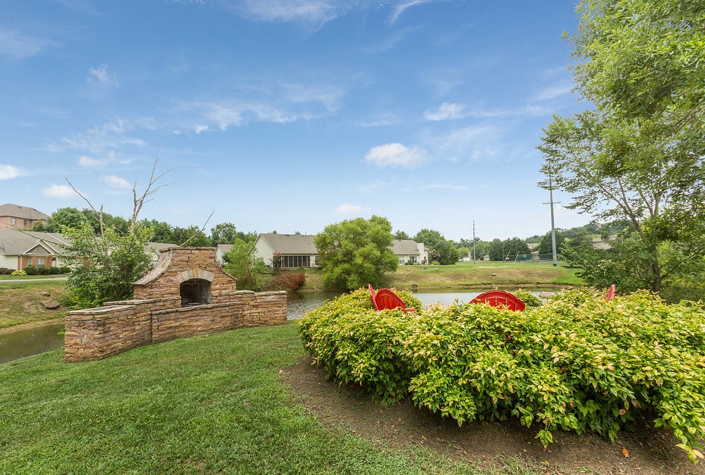 a backyard with a brick fireplace and a pond