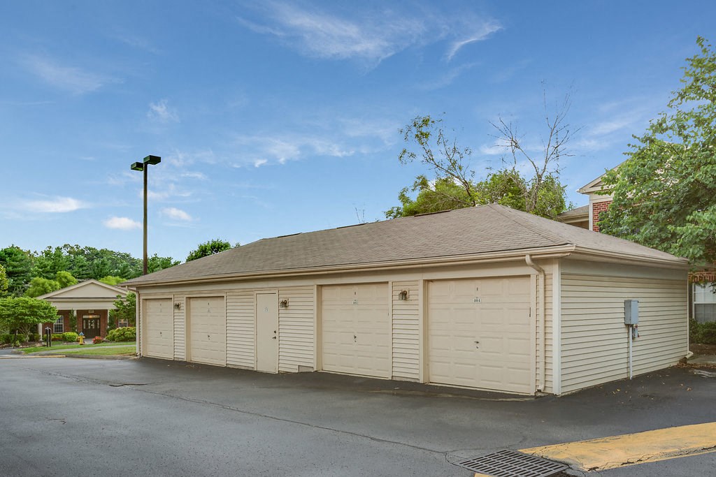 a small garage with white doors in a parking lot