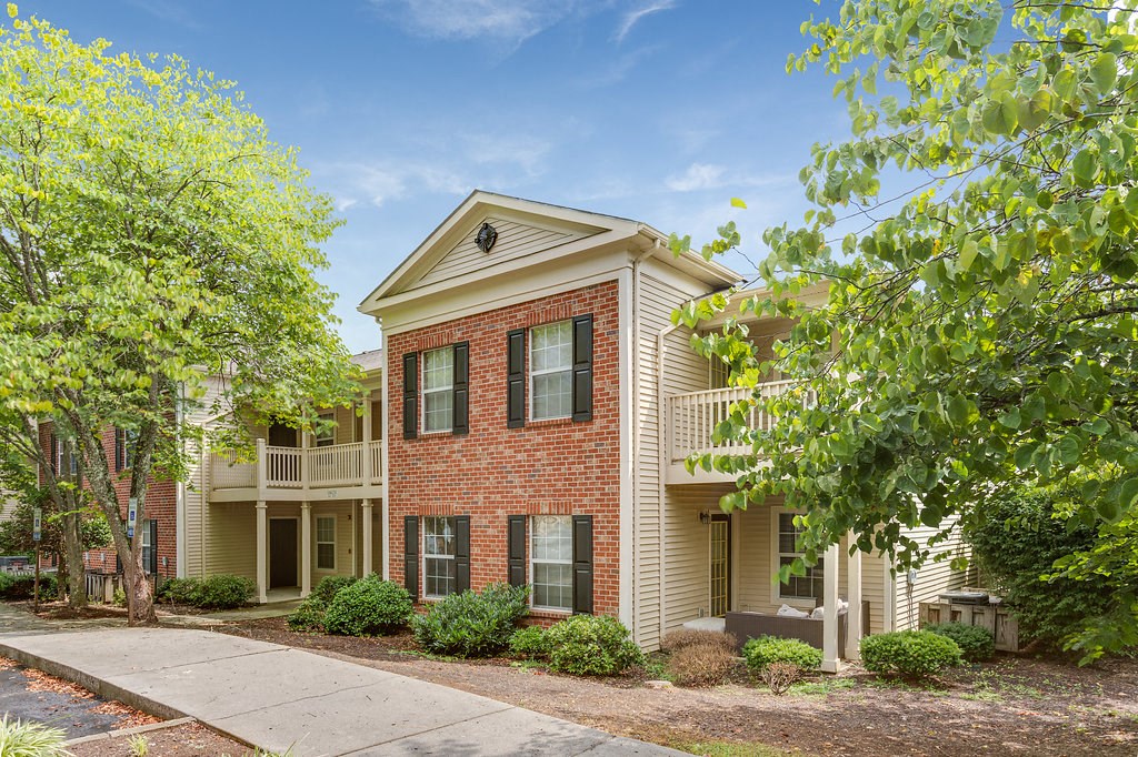 an apartment building with a sidewalk and trees
