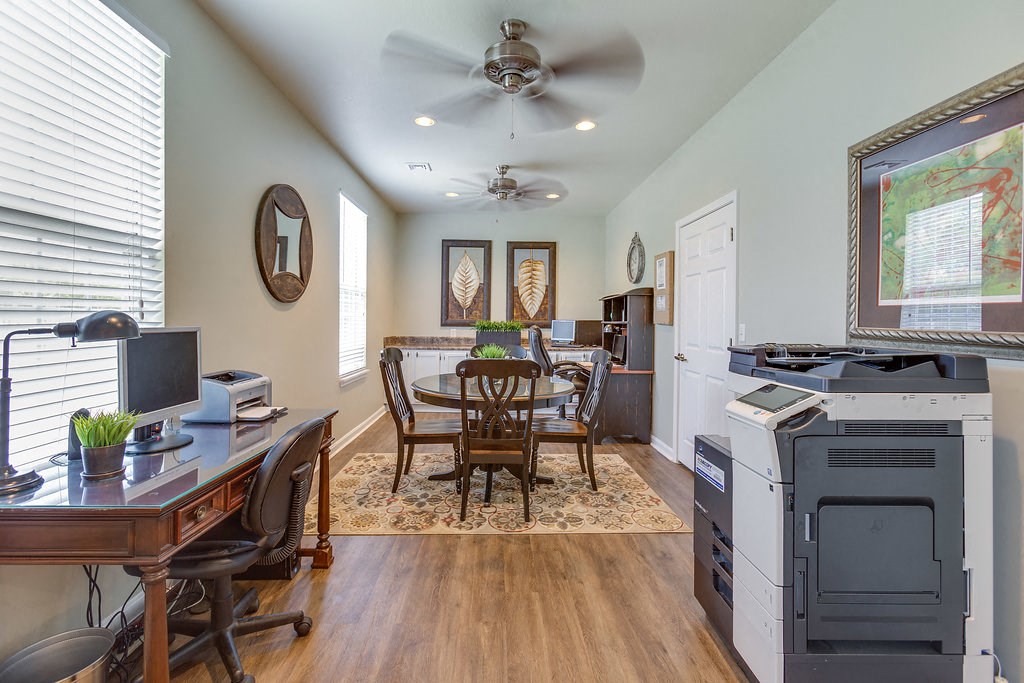 a home office with a desk and a printer and a dining room table