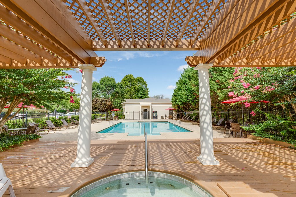 the pool is under a large wooden patio