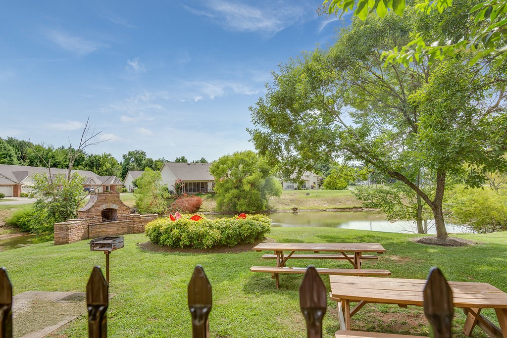 a park with picnic tables and a river in the background