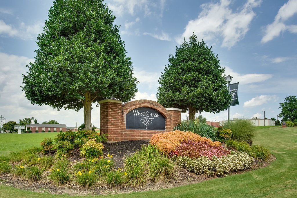 the park at westchase park entrance sign with flowers and trees