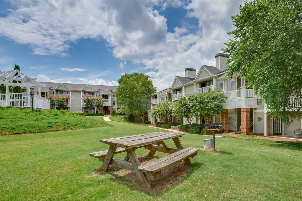 a picnic table in a park in front of an apartment building