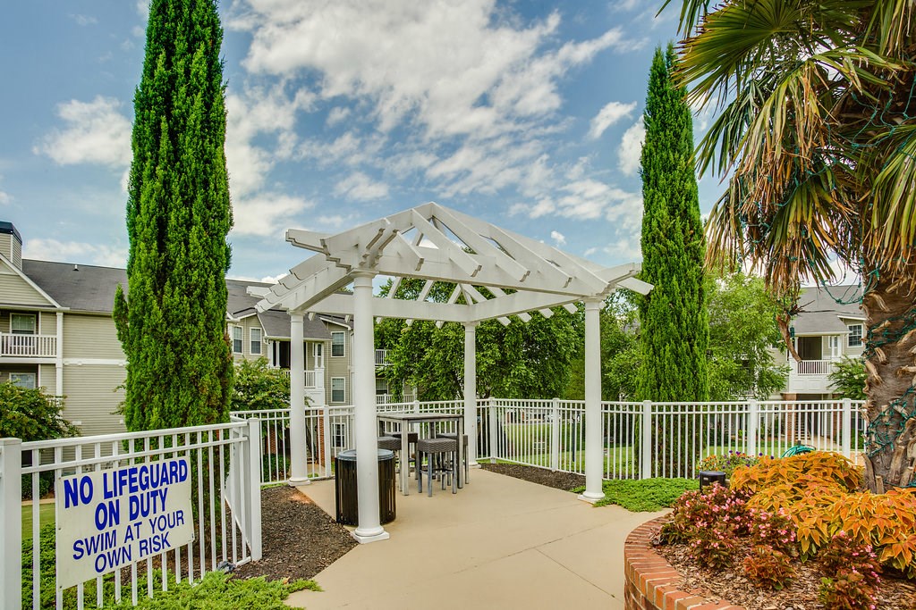 a patio with a white gazebo and a table and chairs under it