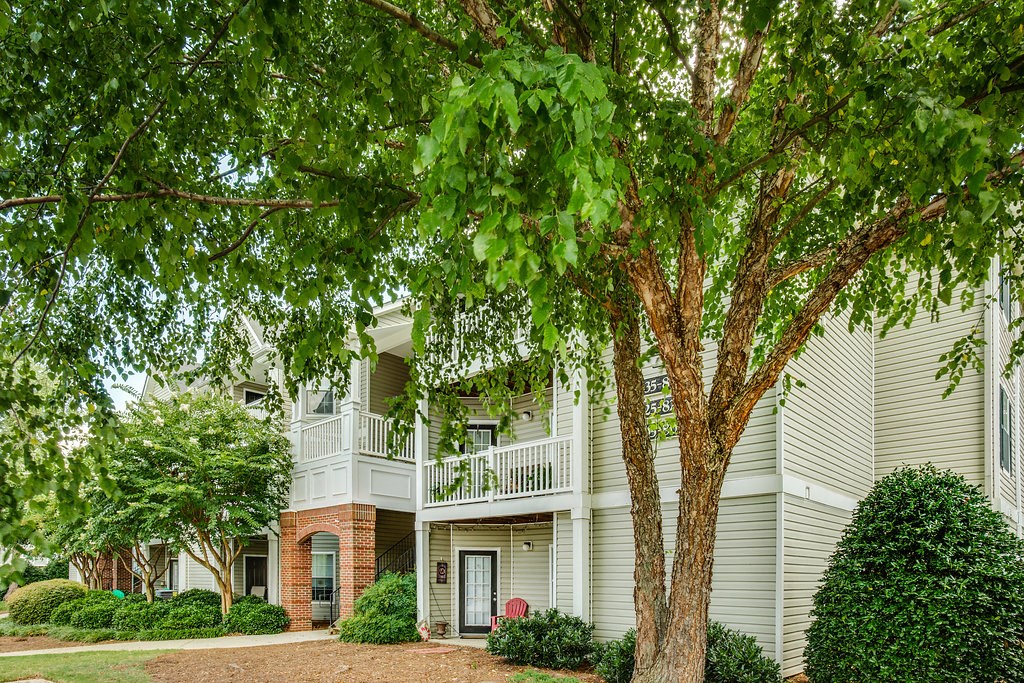 an apartment building with a tree in front of it