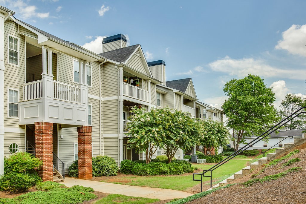 a row of townhomes with stairs and trees
