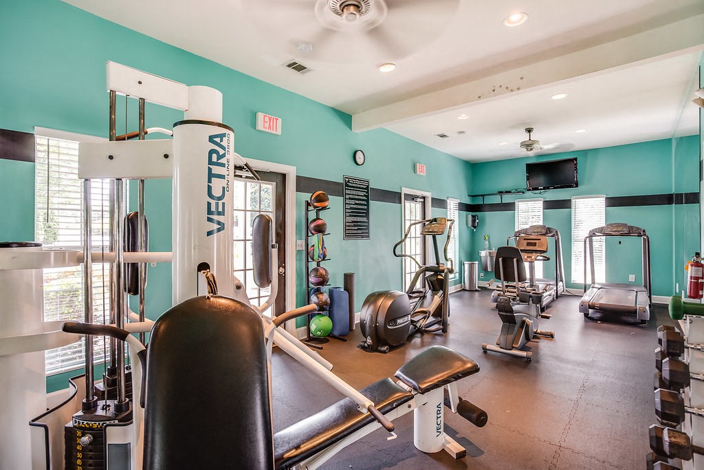 a gym with weights and other exercise equipment in a room with blue walls