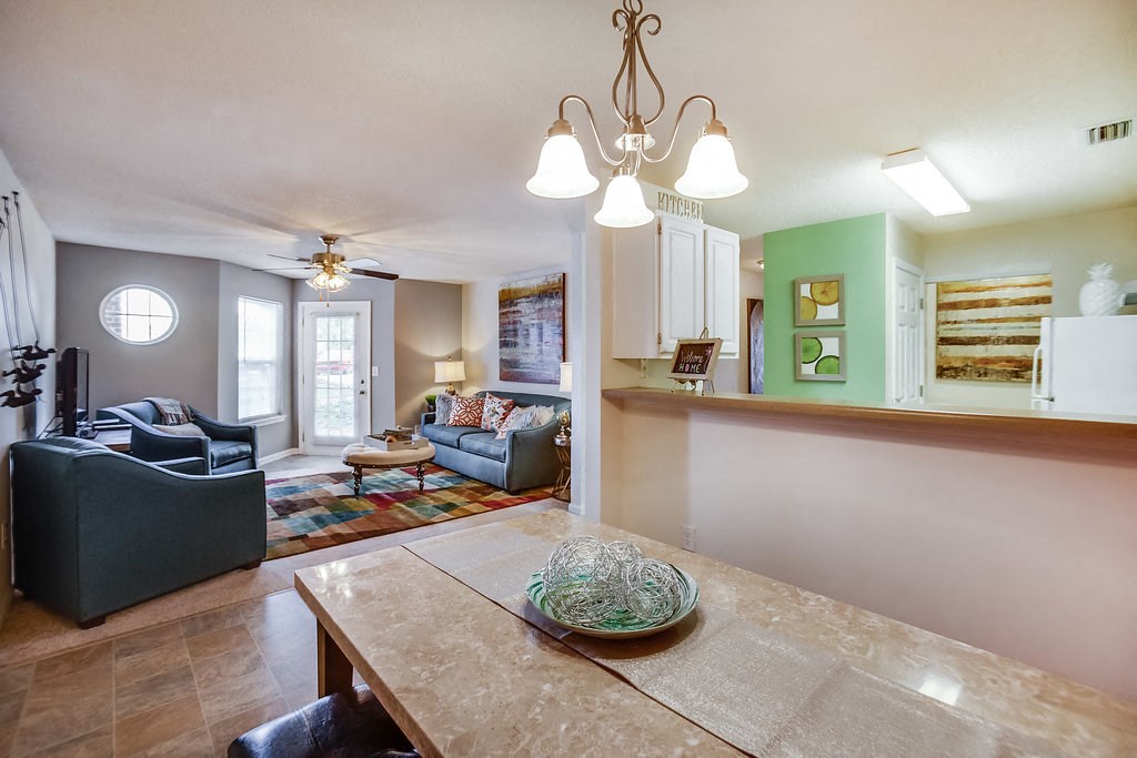 a living room and dining room with a table and chairs