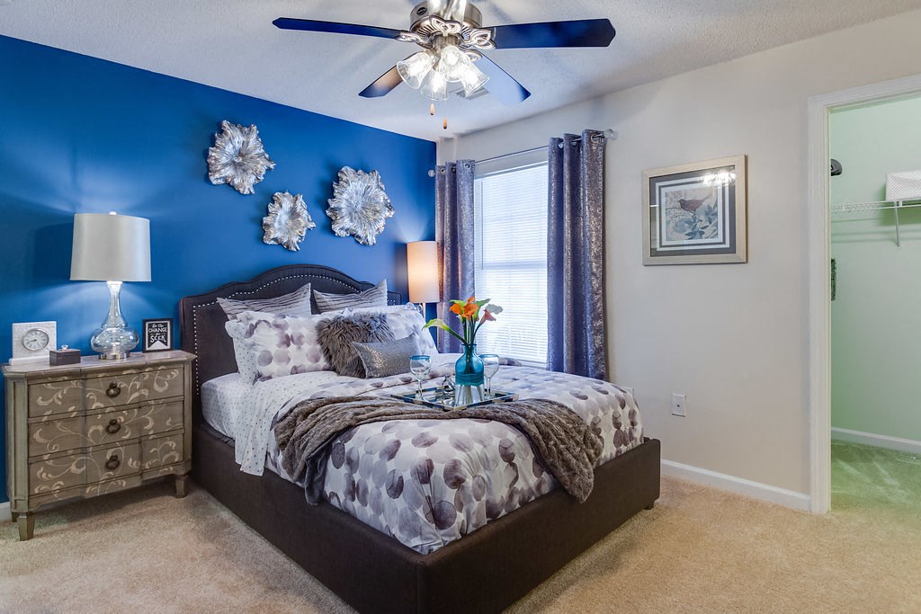 a bedroom with a bed and a ceiling fan
