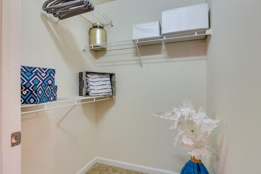 a closet with some towels and a vase in it