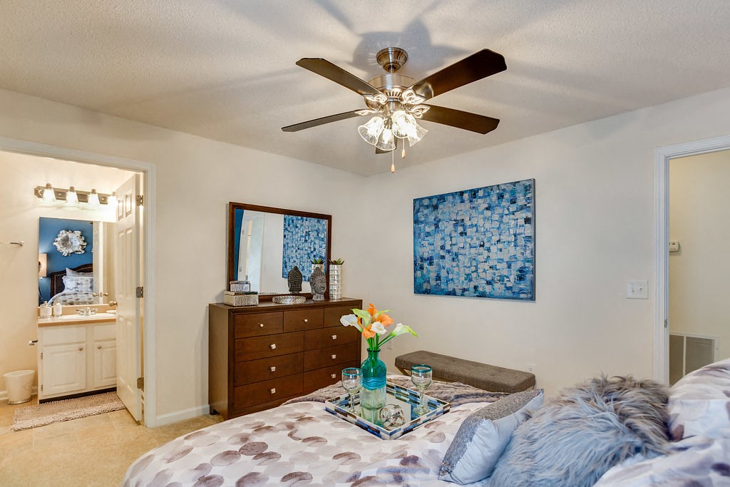 a bedroom with a bed and a ceiling fan