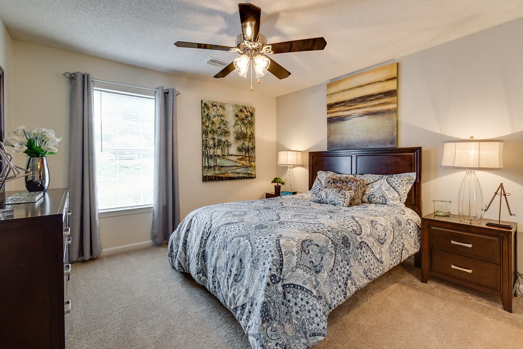 a bedroom with a bed and a ceiling fan