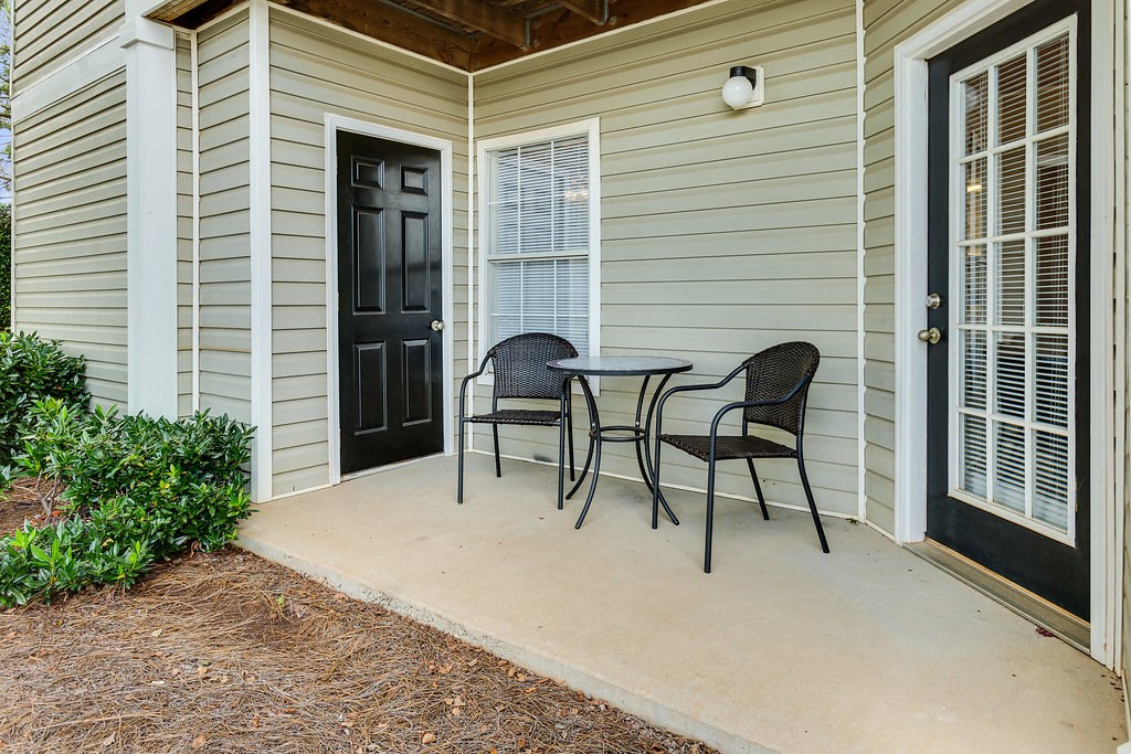a patio with a table and chairs and a black door
