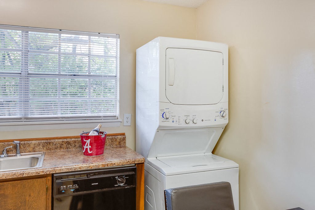 a washer and dryer in a kitchen with a sink and a window