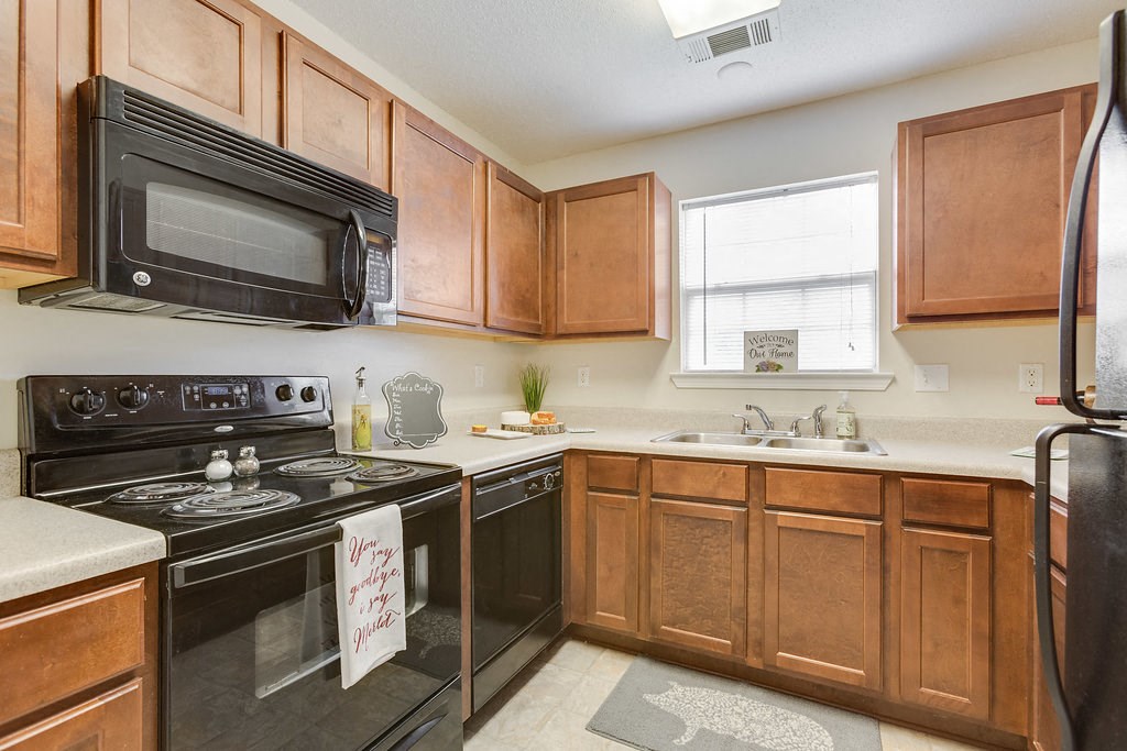 a kitchen with black appliances and wooden cabinets
