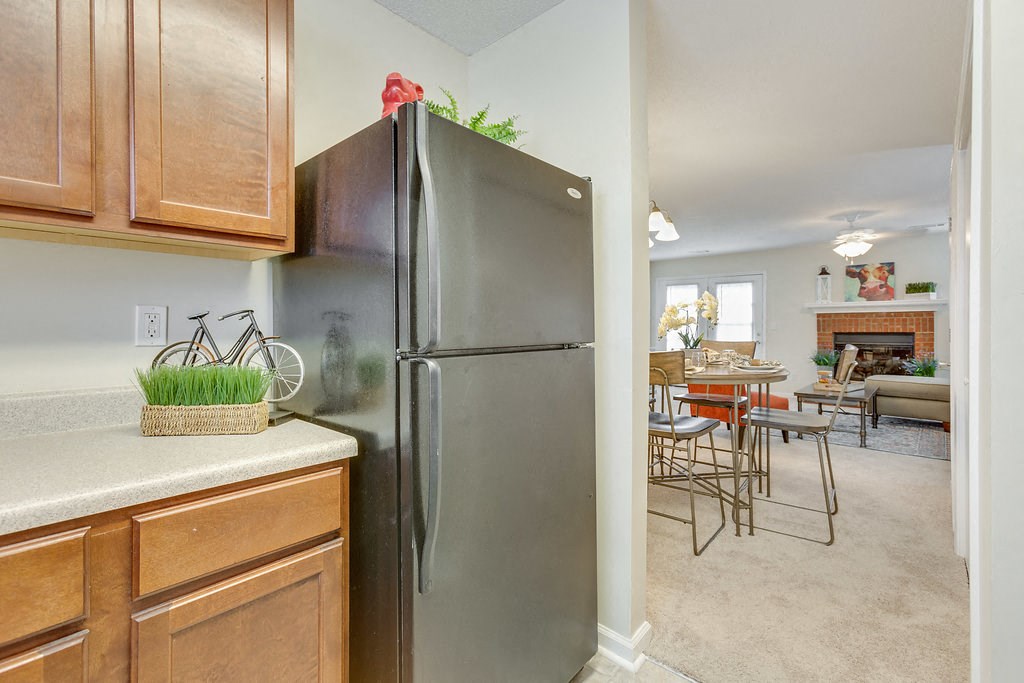 a kitchen with a stainless steel refrigerator and wooden cabinets