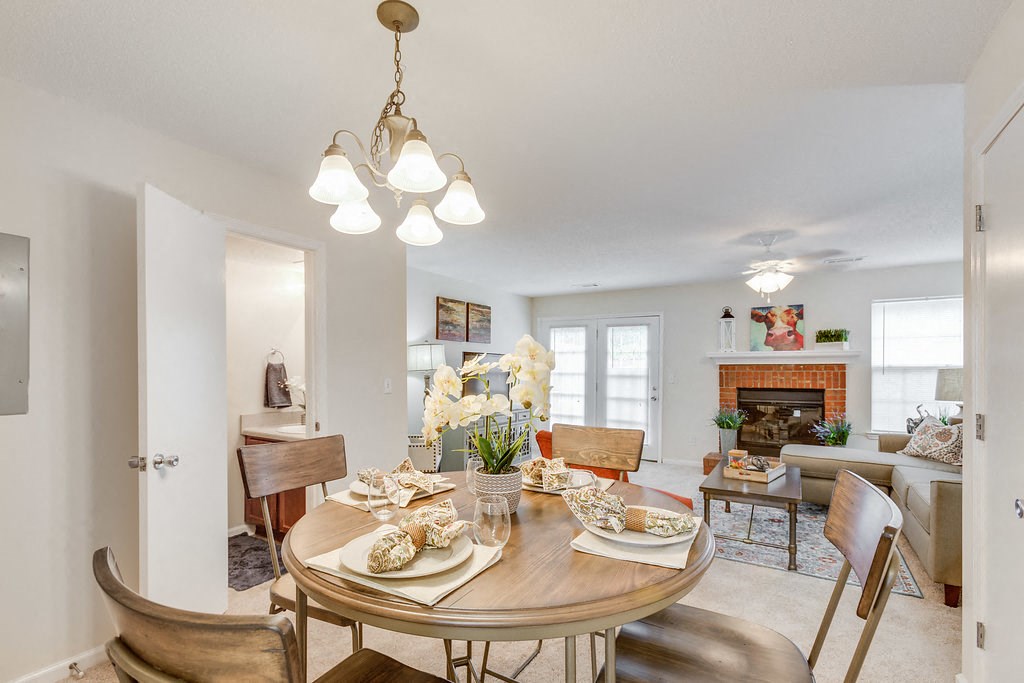 a living room and dining room with a table and chairs