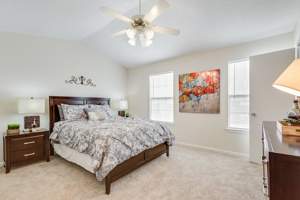 a bedroom with a bed and a ceiling fan