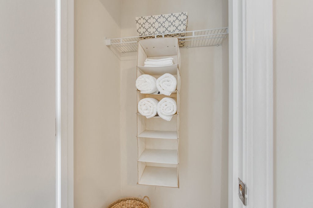 a closet with white shelves and towels