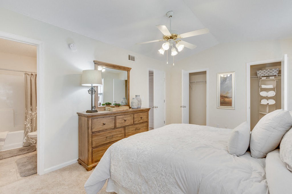 a bedroom with a large bed and a ceiling fan