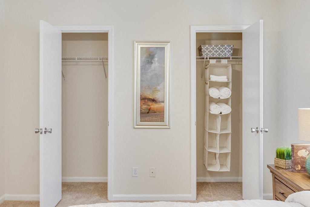 a bedroom with closet doors and a painting on the wall
