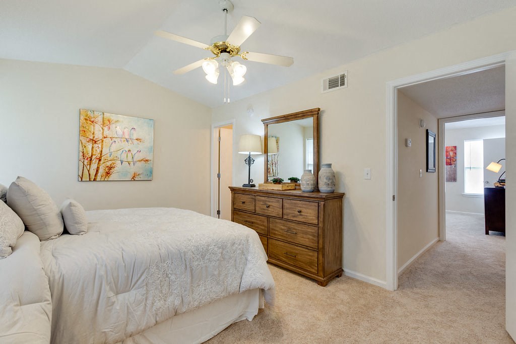 a bedroom with a bed and a ceiling fan