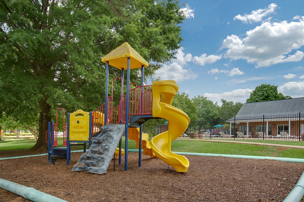 a playground at a park with a yellow slide