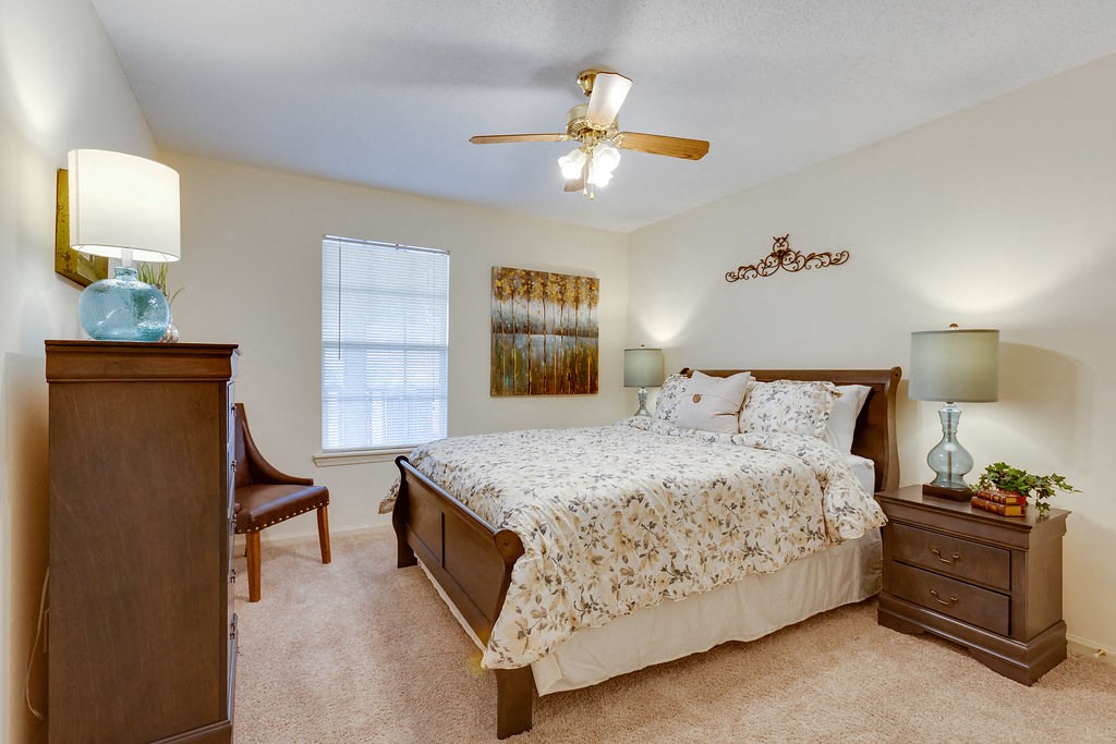a bedroom with a bed and a ceiling fan