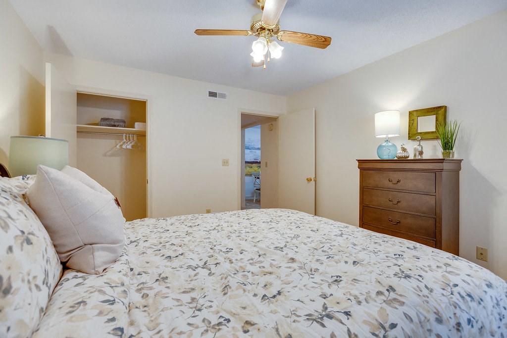 a bedroom with a bed and a ceiling fan