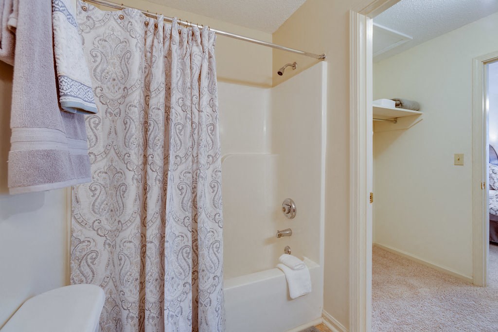 a bathroom with a shower and a toilet and a shower curtain