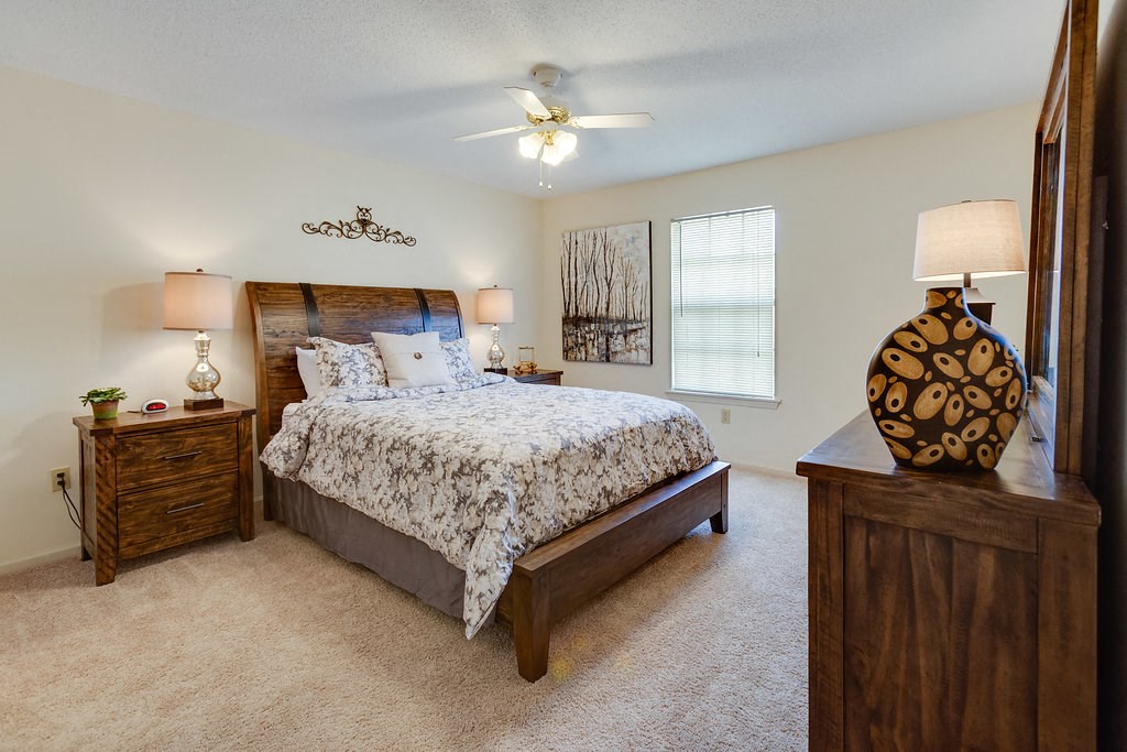a bedroom with a bed and a ceiling fan