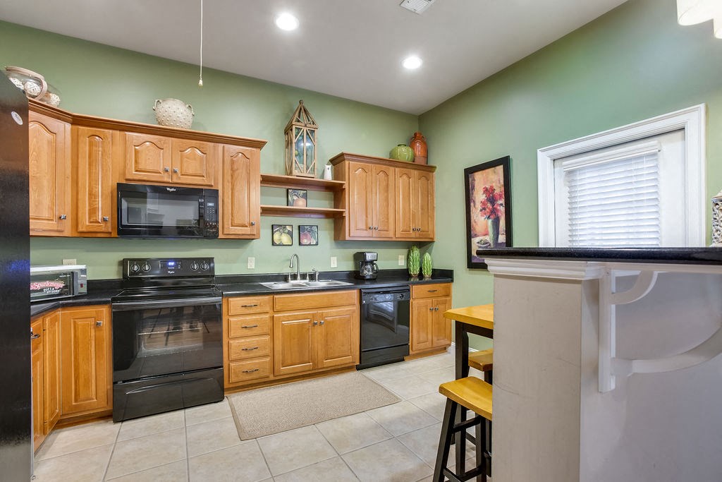 a kitchen with black appliances and wooden cabinets