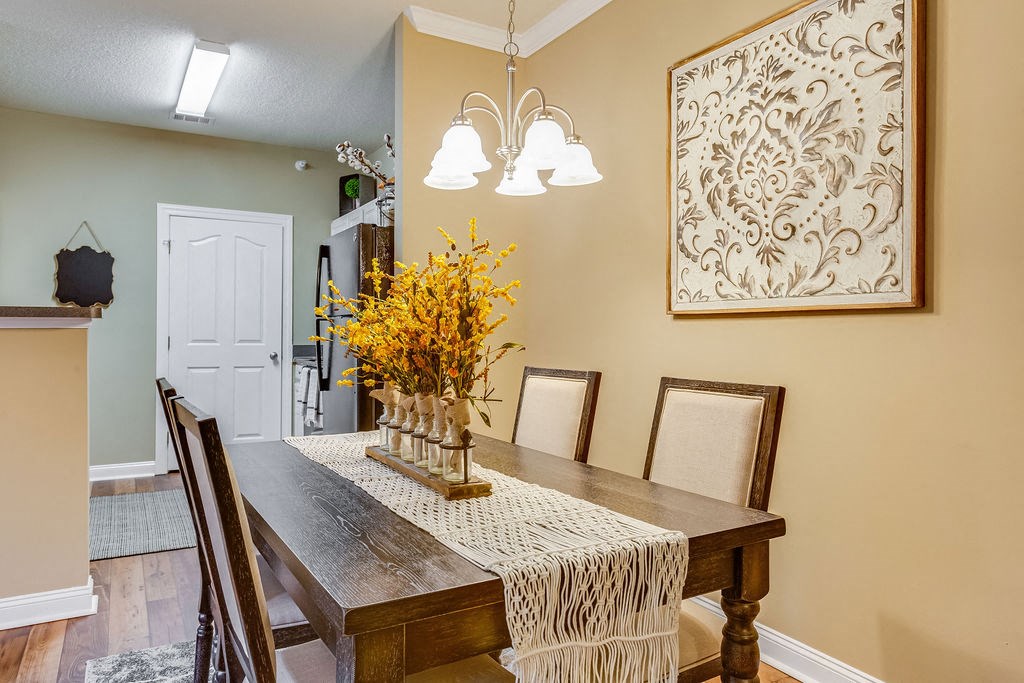 a dining room table with a vase of flowers on it