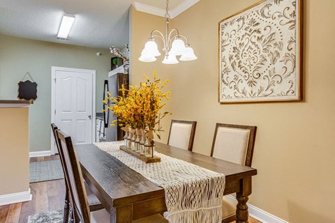 a dining room table with a vase of flowers on it