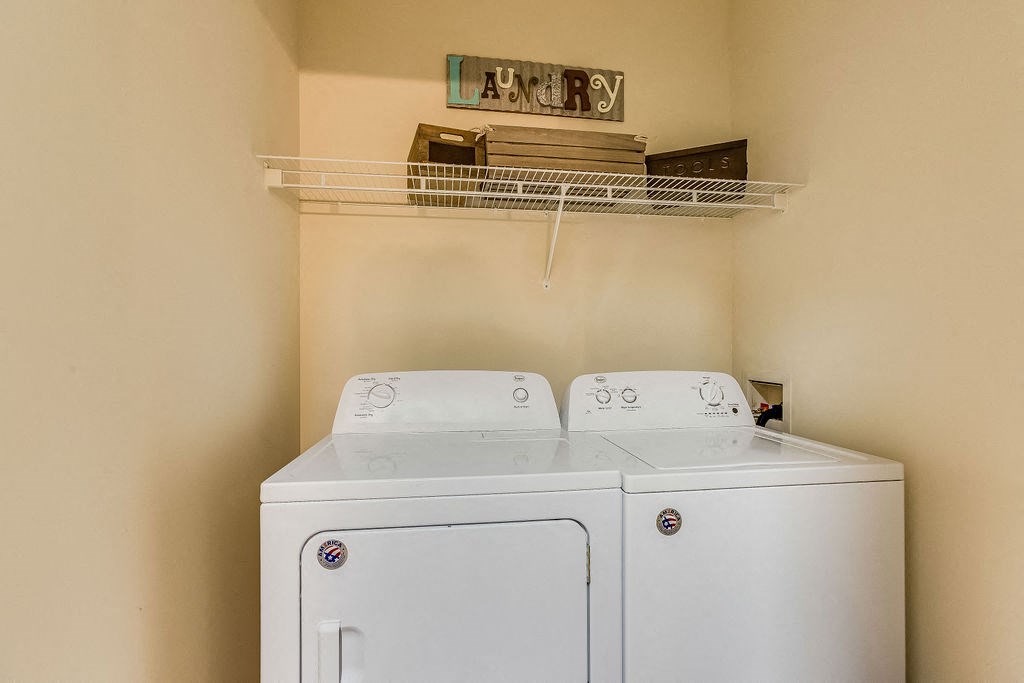 a washer and dryer in a laundry room with a shelf over the top