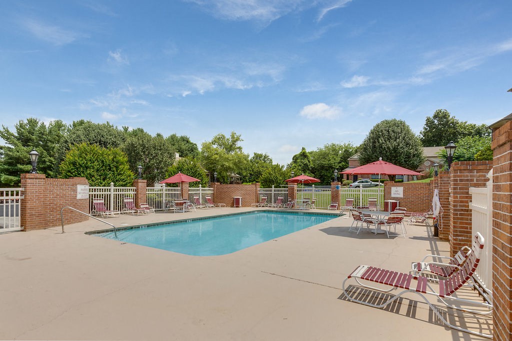 a swimming pool with chairs and umbrellas