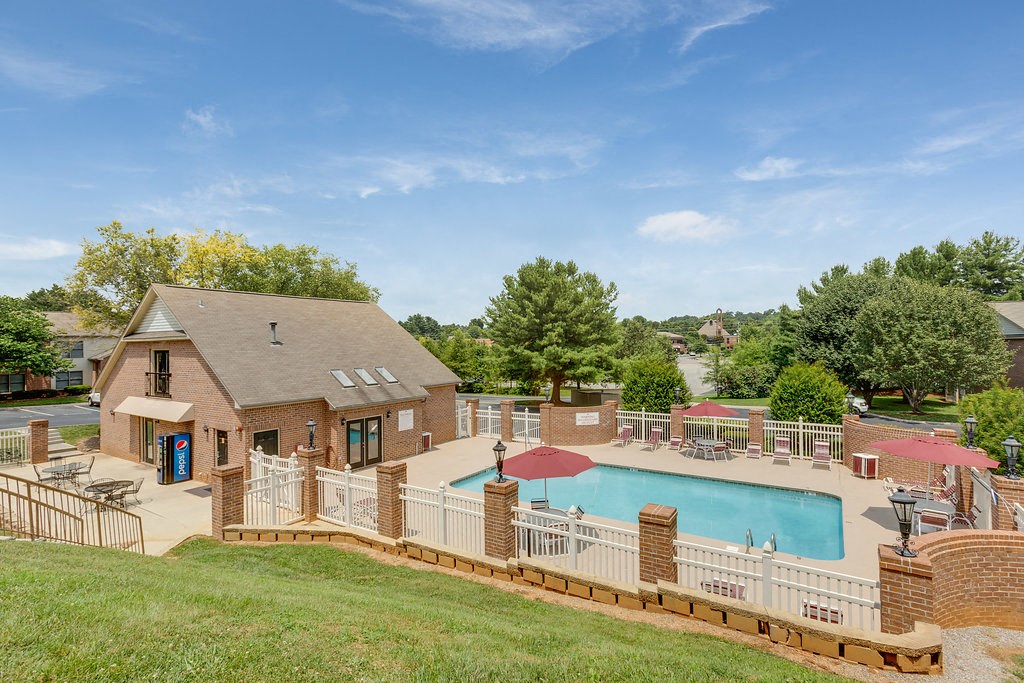 a backyard with a pool and a house with a fence