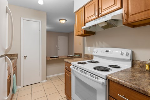 A white stove in a kitchen with brown cabinets.