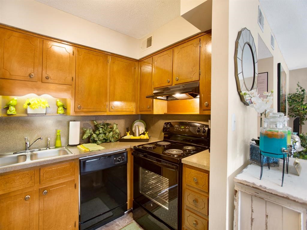 a kitchen with black appliances and wooden cabinets