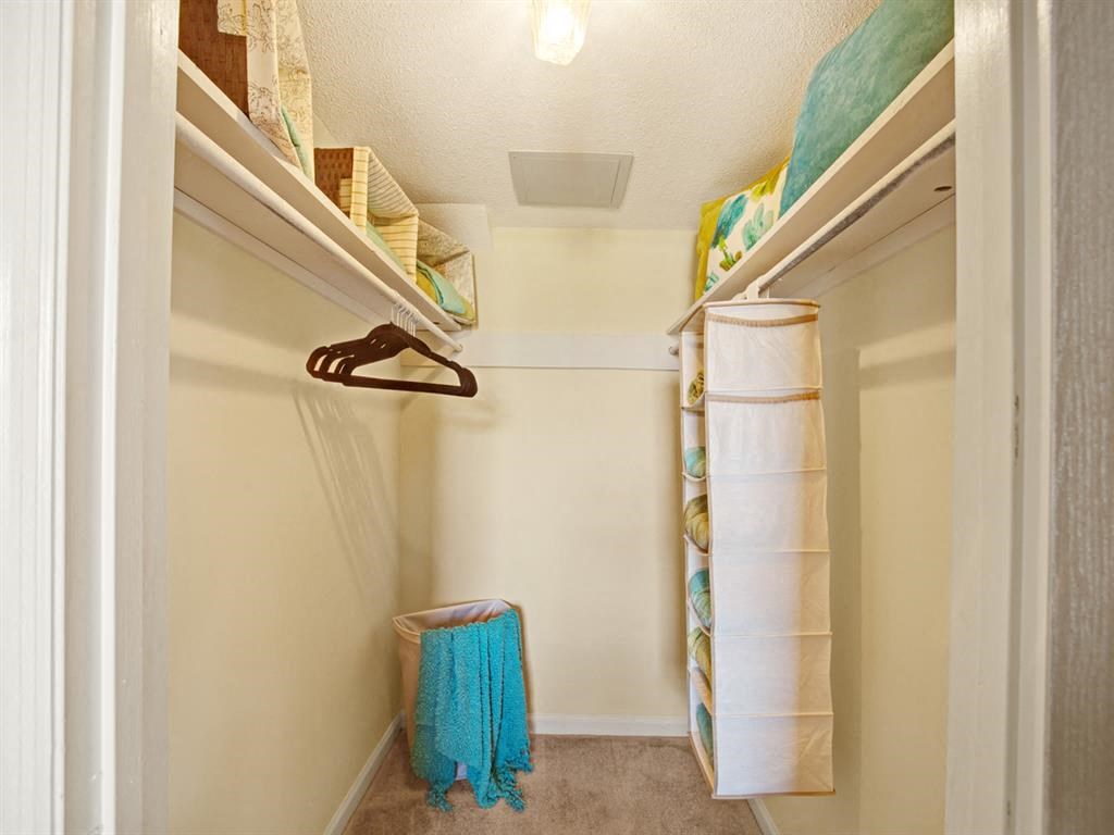 a walk in closet with a shoe rack and towels