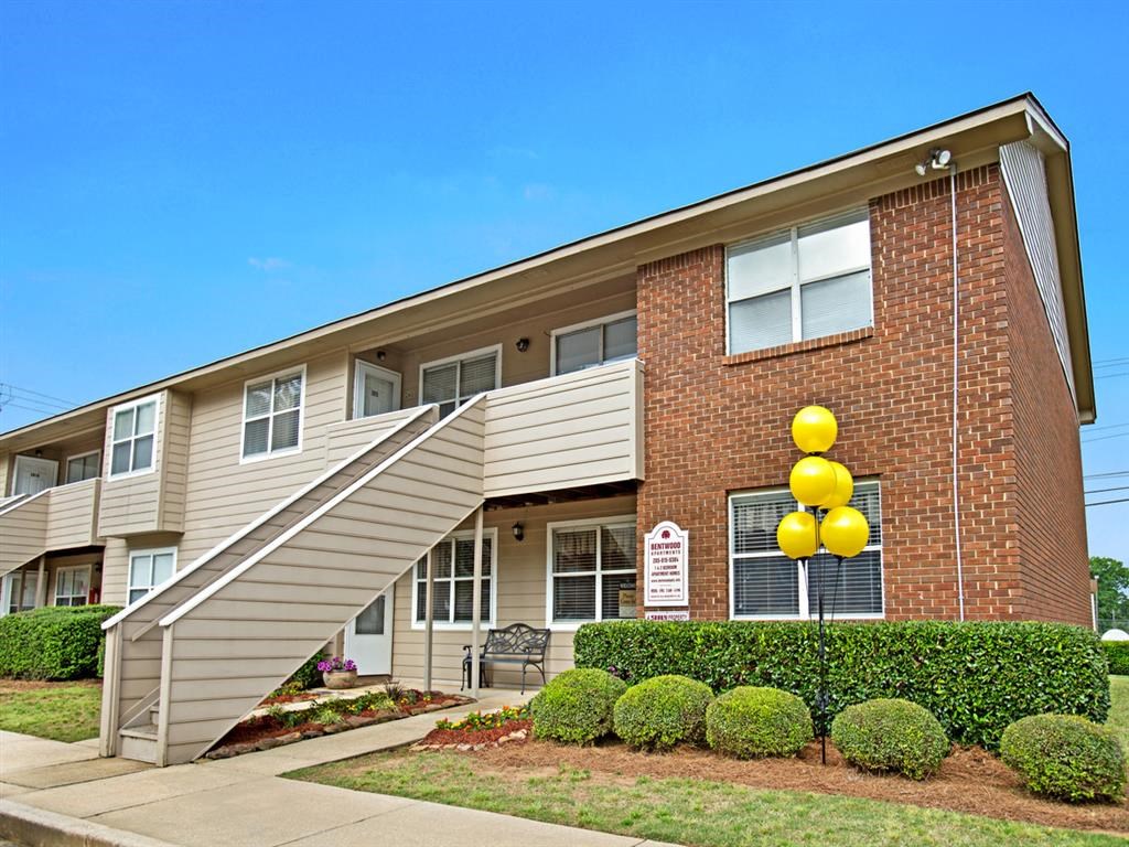 an apartment building with a yellow sign in front of it