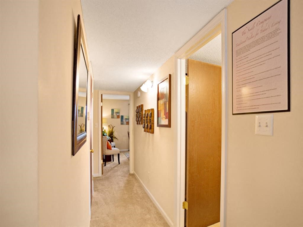 a hallway with a hallway mirror and a door to a living room