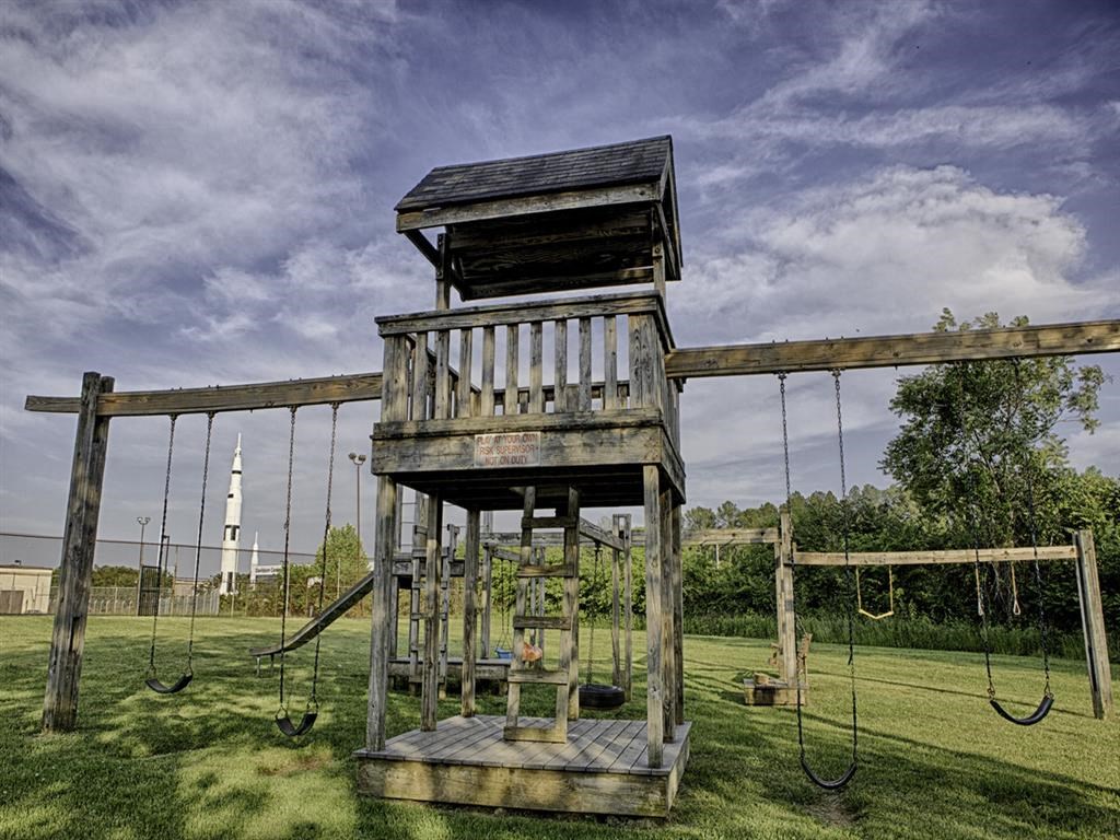 a tree house sits on top of a swing set