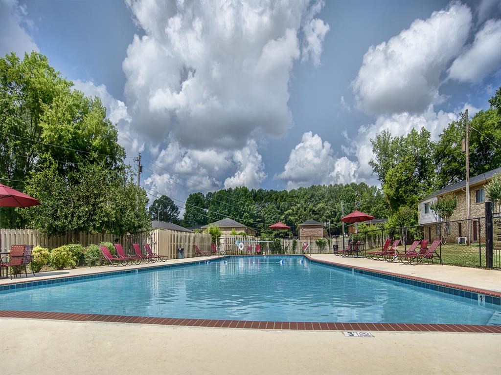 a swimming pool with chairs and umbrellas around it