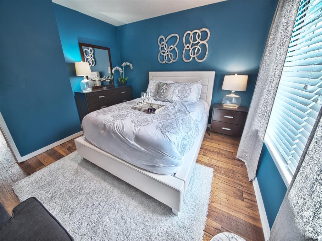 a bedroom with blue walls and a white bed