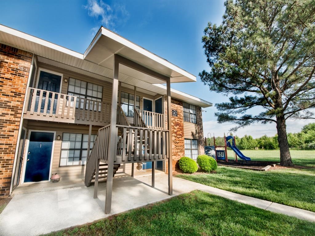 a building with a staircase and a playground in front of it
