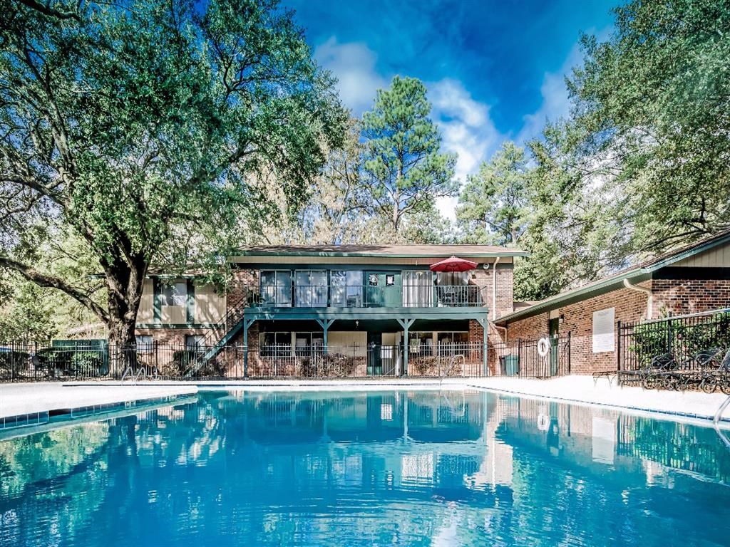 the pool is in front of a house with a pool