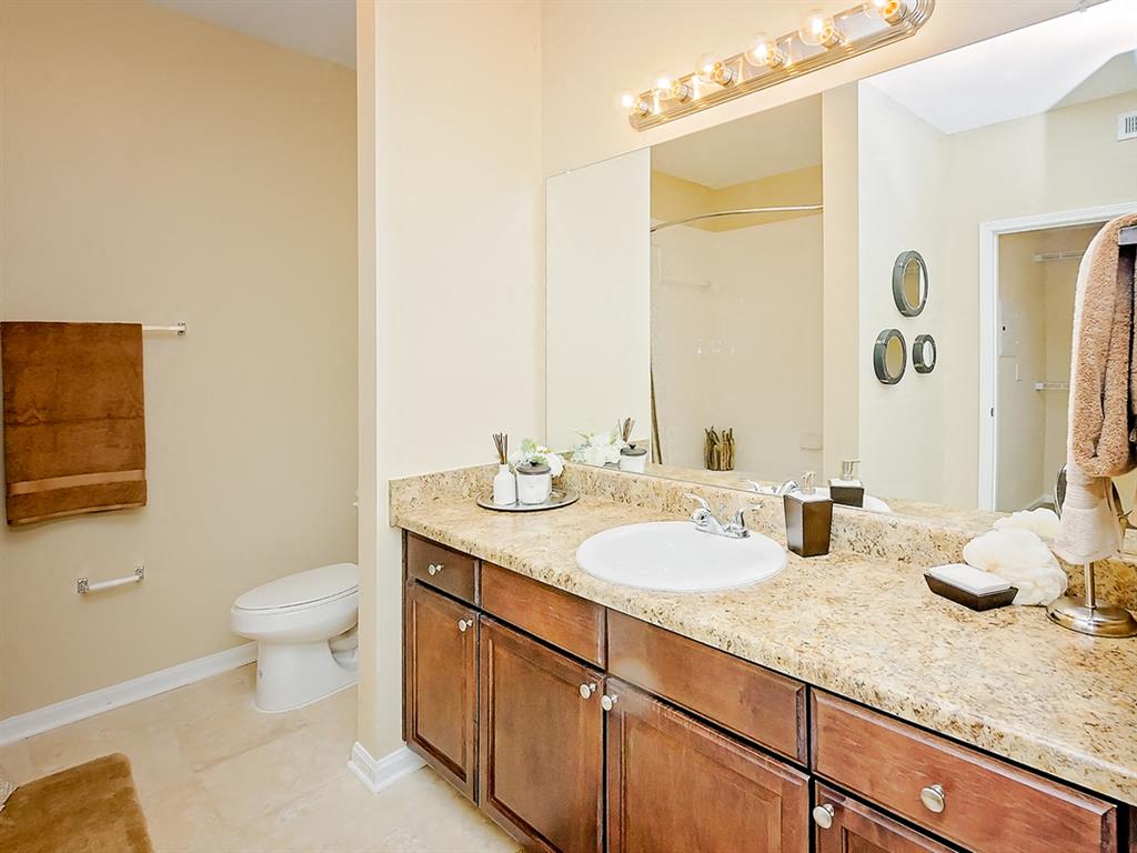 bathroom with a white porcelain sink, granite countertop and brown cabinets