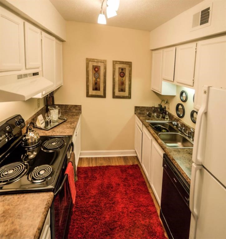 a kitchen with a stove refrigerator and a sink